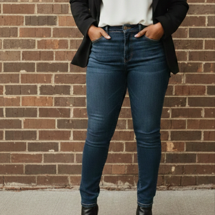 Aisha wearing a black blazer, white blouse, dark skinny denim and black ankle boots