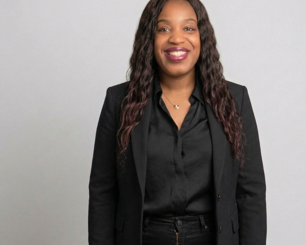 An image of a model wearing a black blazer, black blouse, and black skinny denim