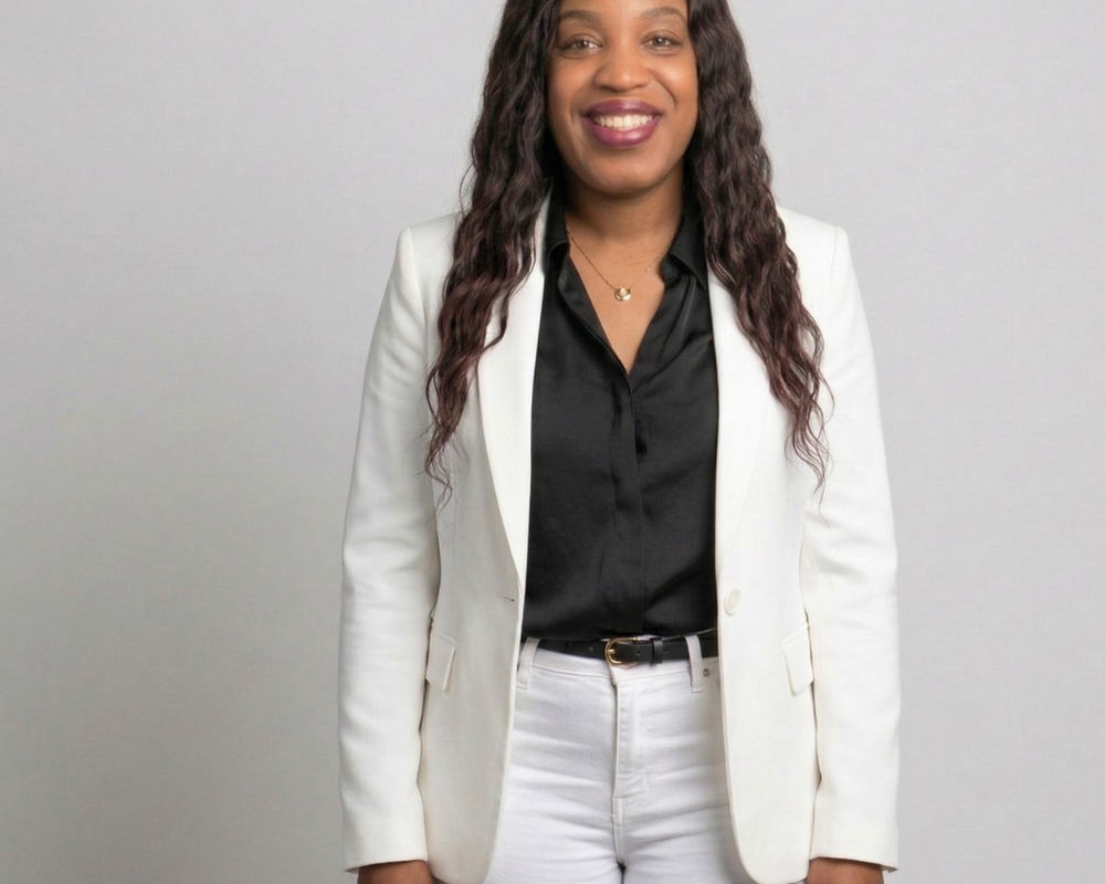 An image of a model wearing a white blazer, black blouse and white skinny jeans