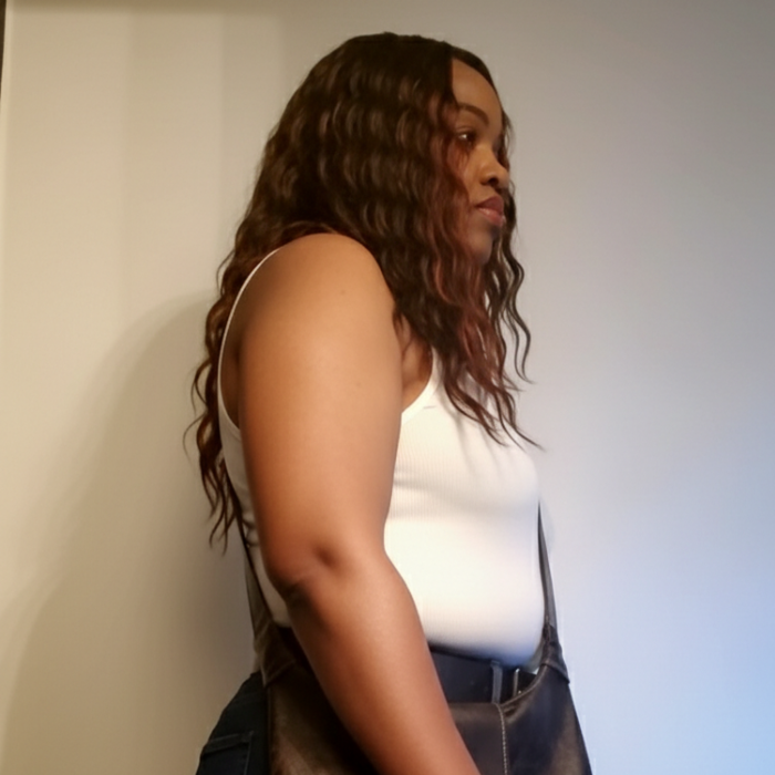 Aisha wearing a white top and dark denim