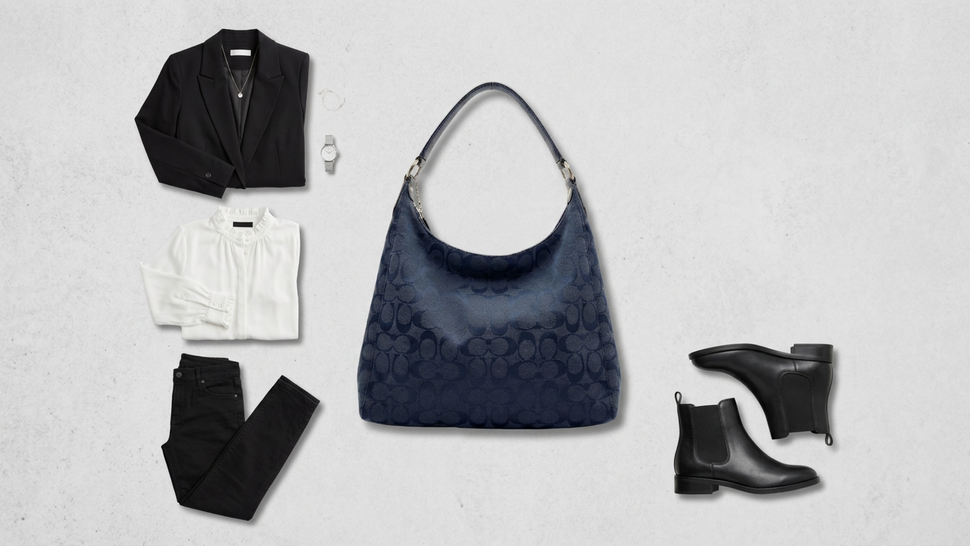 Flat lay of a black blazer, white shirt, black jeans, navy patterned handbag, watch, necklace, and black ankle boots