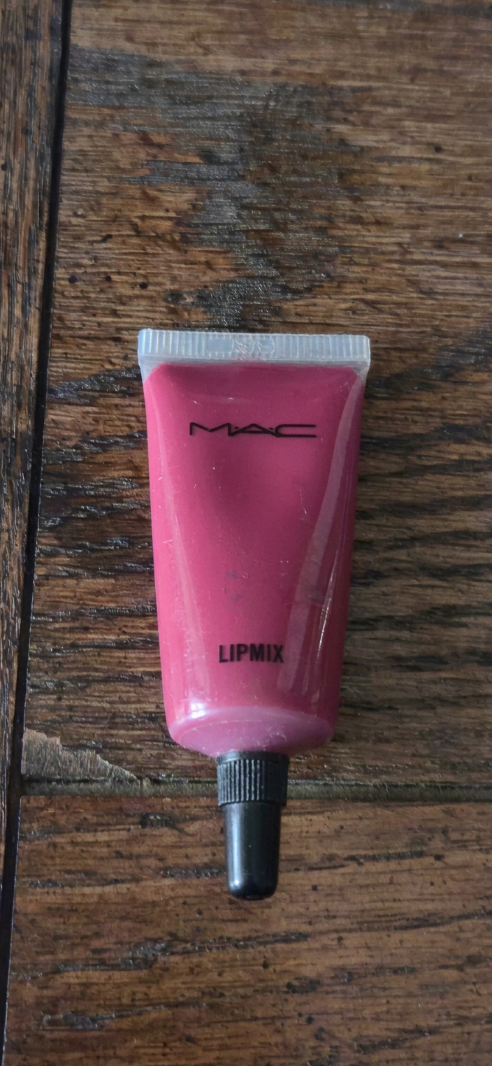 Pink MAC Lipmix cosmetic tube on a wooden surface